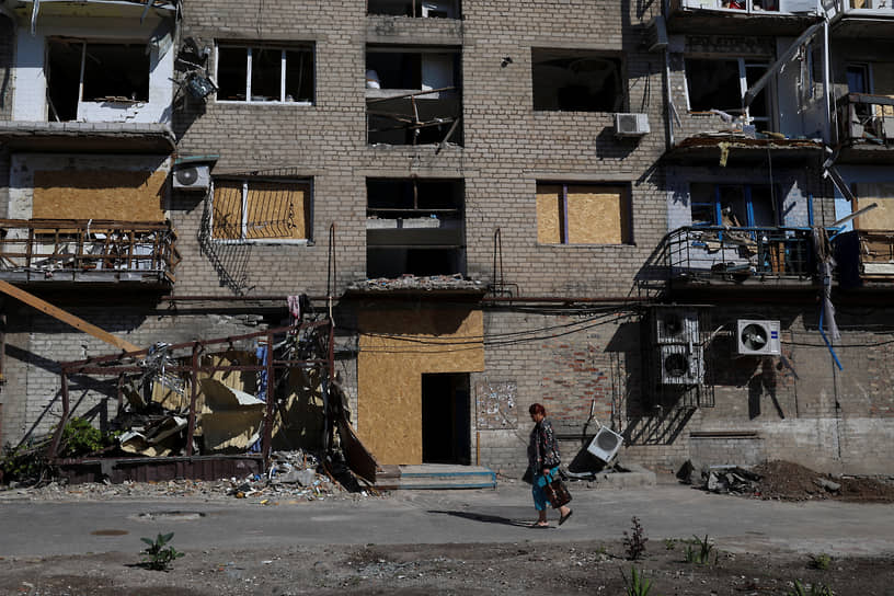 Женщина около поврежденного дома в Покровске