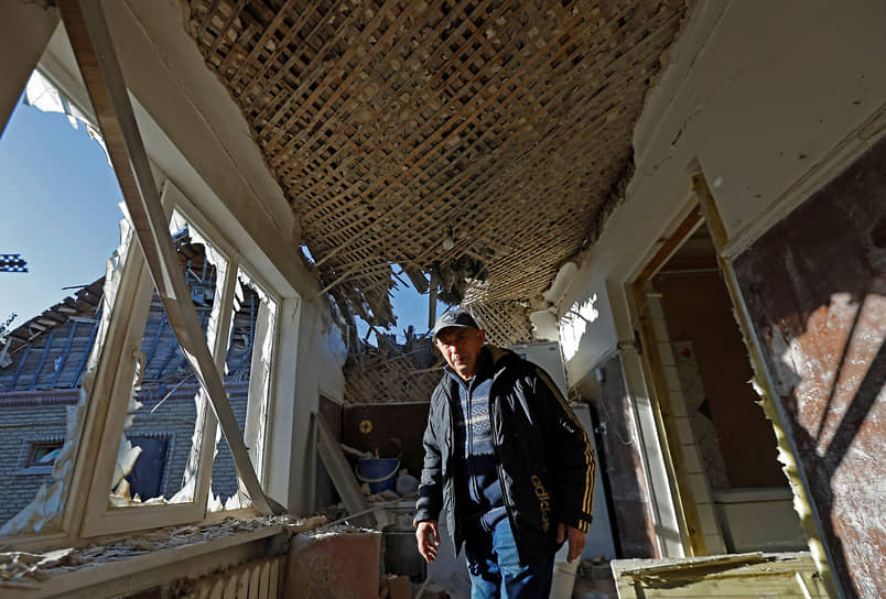Местный житель осматривает свой разрушенный дом в Донецке