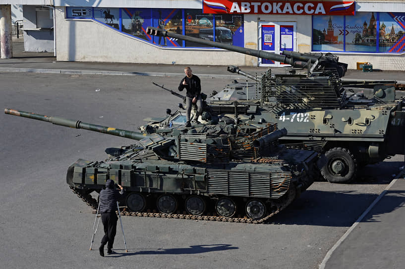 Мужчина позирует на танке на выставке украинской военной техники в Луганске 