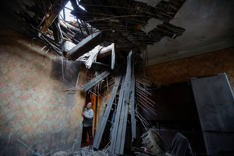 Жительница Донецка осматривает квартиру после обстрела