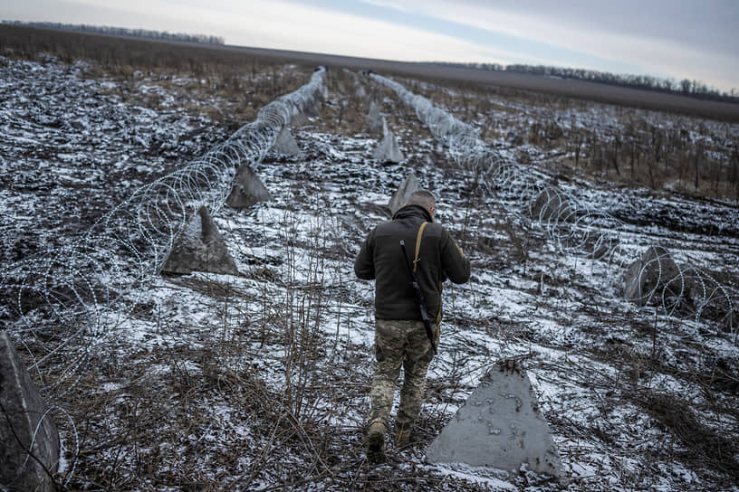 Украинский военнослужащий идет вдоль оборонительных сооружений в Харьковской области