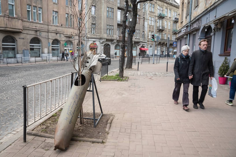 Жители Львова проходят рядом с российской ракетой, сбитой возле Славянска и ставшей арт-объектом