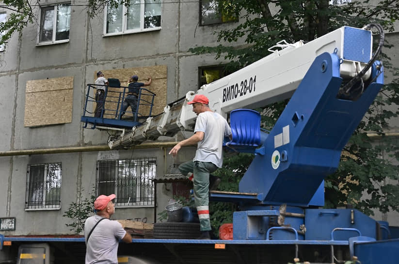 Работники коммунальной службы закрывают разбитые окна в городе Дружковка 