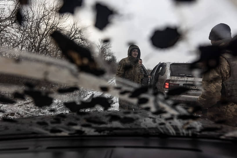 Украинские военные буксируют застрявший в грязи автомобиль по пути на боевую позицию в направлении Купянска в Харькове
