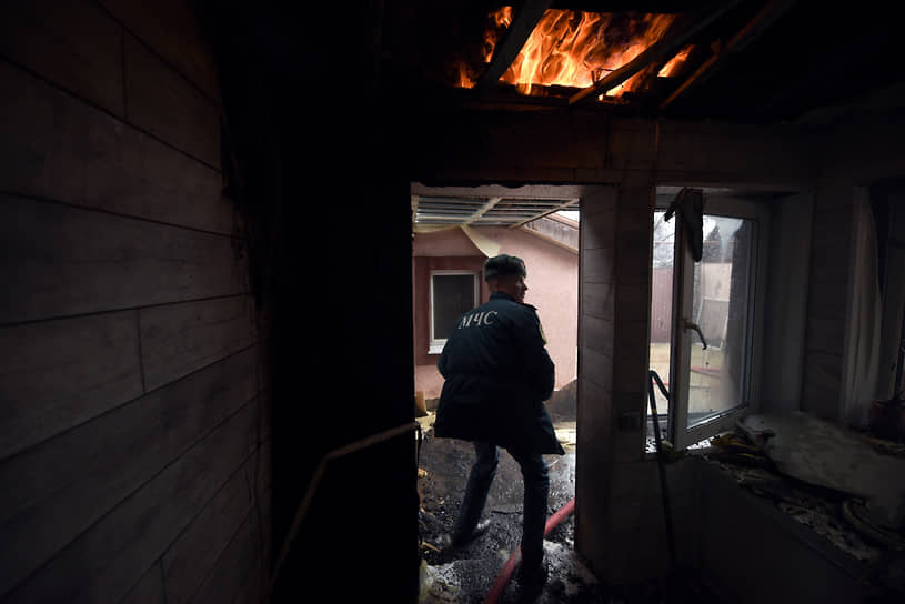 Сотрудники МЧС устраняют последствия попадания снаряда в частный дом в Донецке