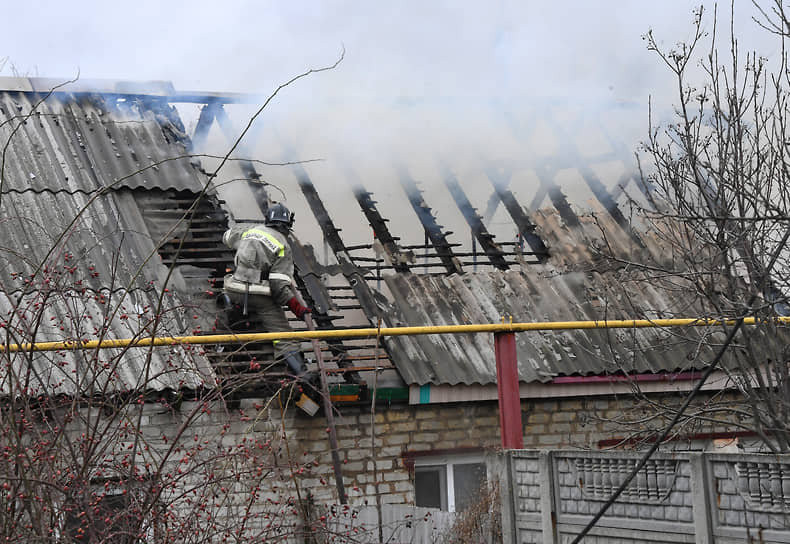 Пожарный тушит дом после обстрелов в Донецке
