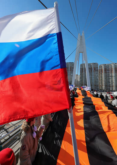 Активисты разворачивают георгиевскую ленту на мосту через Москву-реку в Павшинской Пойме