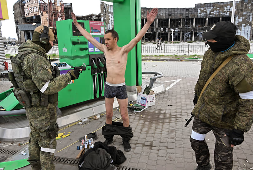 Бойцы спецназа ДНР досматривают человека на заправке