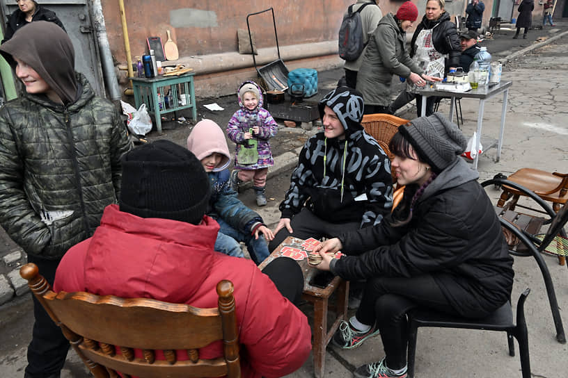 Жители во дворе жилого дома в Правобережном районе города. Подростки играют в карты