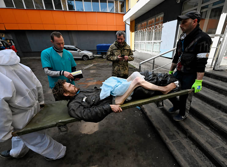 Мужчина на носилках у областной больницы № 2 города Мариуполя