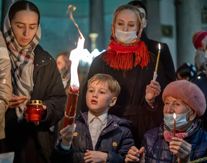 Жители Санкт-Петербурга держат Благодатный огонь в Казанском соборе