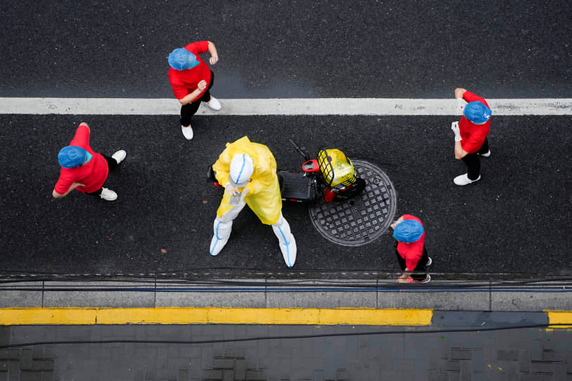 Шанхай, Китай. Рабочие в защитных костюмах во время карантина