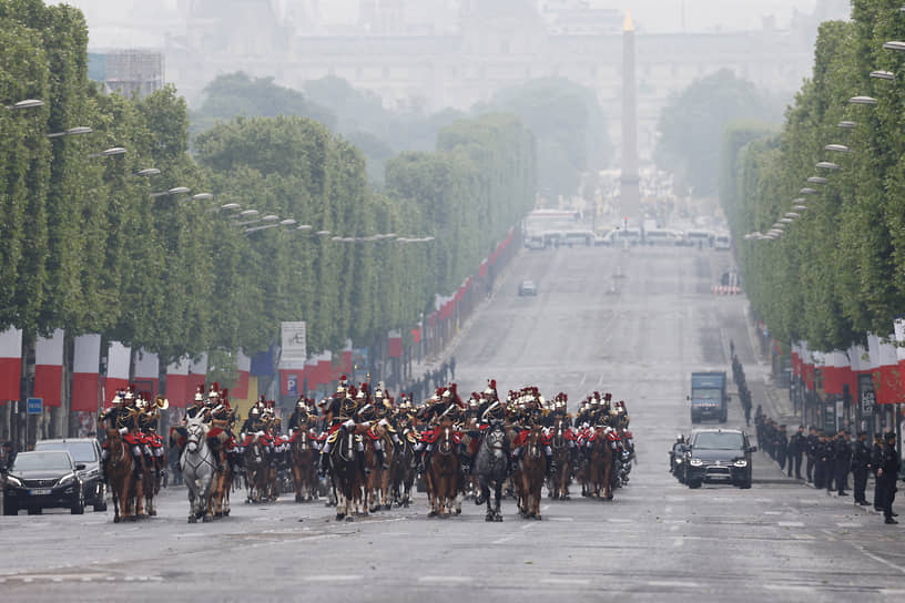 Кортеж президента Франции в сопровождении гвардейцев направляется к Триумфальной Арке