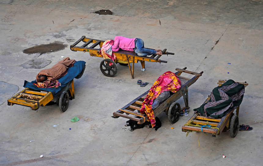 Нью-Дели, Индия. Носильщики железнодорожной станции спят на своих тележках
