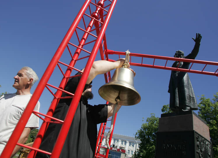 Активисты вешают колокол на каркас рядом с памятником Козьме Минину в Нижнем Новгороде 