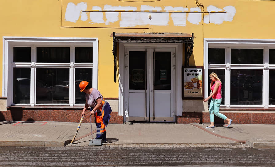 Сотрудница коммунальной службы подметает улицу возле бывшего ресторана «Макдоналдс» на Арбате