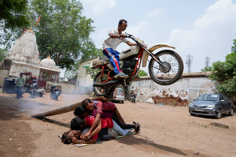 Ахмедабад, Индия. Местные жители выполняют трюк перед процессией, посвященной празднику колесниц Ратха-ятре 