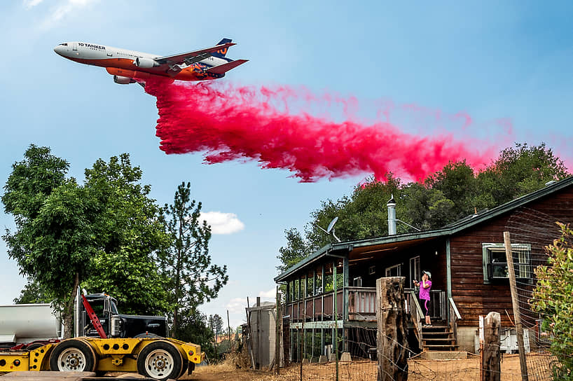 Амадор, США. Местная жительница наблюдает за тушением лесного пожара с самолета