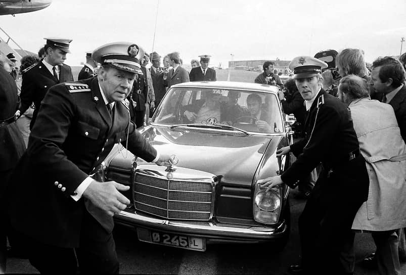 Полиция оттесняет толпу от автомобиля, в котором едет Бобби Фишер, с четвертой попытки долетевший до Исландии. 4 июля 1972 года