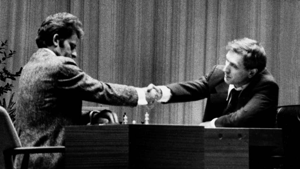 Борис Спасский (слева) и Бобби Фишер пожимают друг другу руки после признания Фишером поражения в первой партии матча за звание чемпиона мира по шахматам