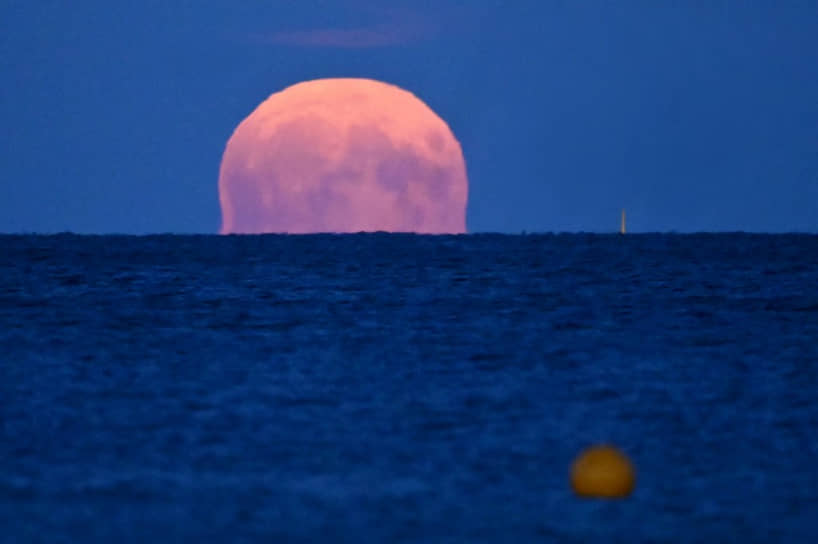 Полная Луна восходит над проливом Эресунн в Дании