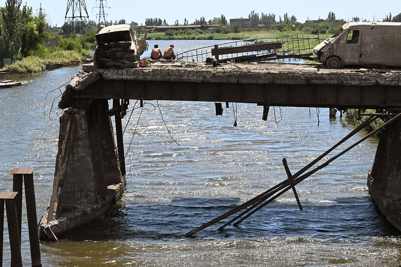 Местные жители ловят рыбу с разрушенного моста напротив металлургического комбината «Азовсталь»