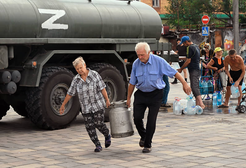 Жители города на пункте раздачи питьевой воды из цистерны