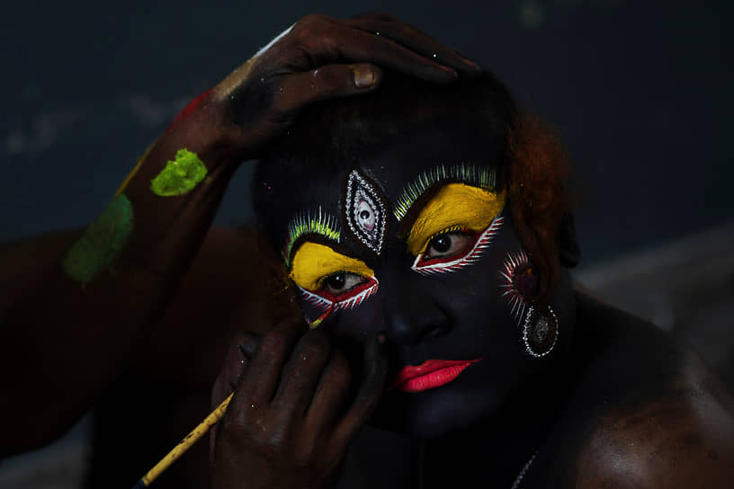 Хайдарабад, Индия. Художник наносит макияж перед выступлением на фольклорном фестивале Боналу