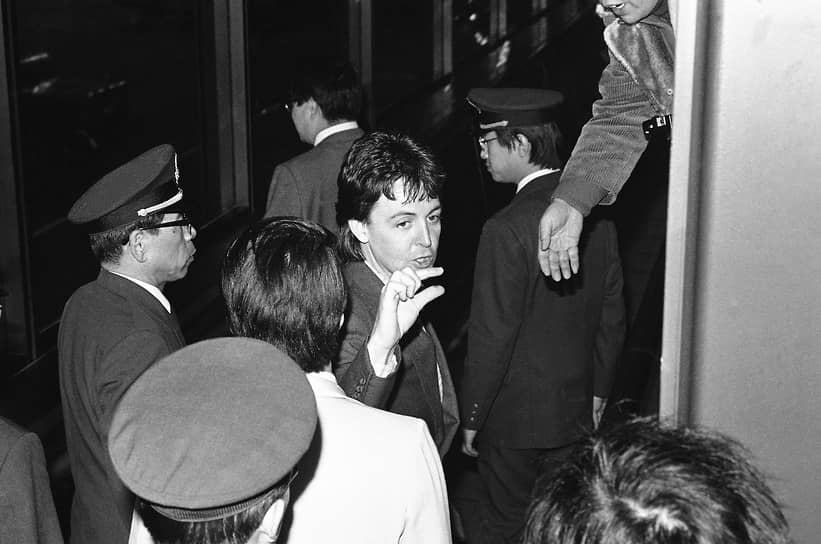 Токио. 25 января 1980 года. Маккартни, которого депортируют из Японии, по пути к самолету отвечает на вопросы журналистов