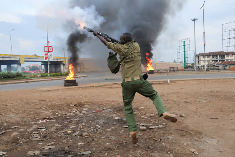 Кисуму, Кения. Полицейский применяет слезоточивый газ против протестующих после объявления результатов президентских выборов