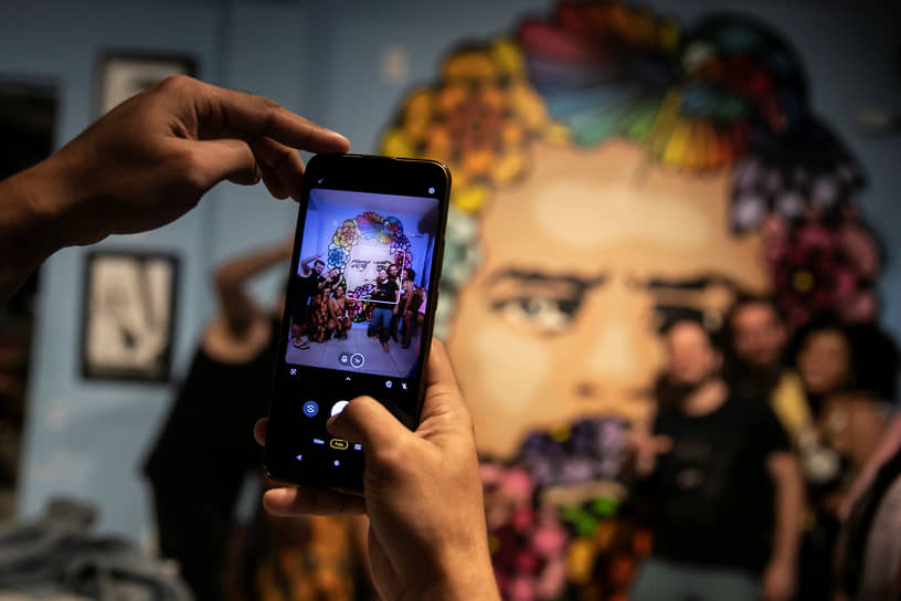 Люди фотографируются в баре у росписи с портретом Лулы да Силвы