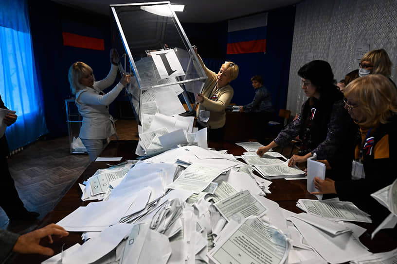 Члены участковой избирательной комиссии обрабатывают бюллетени в Калининском районе Донецка 