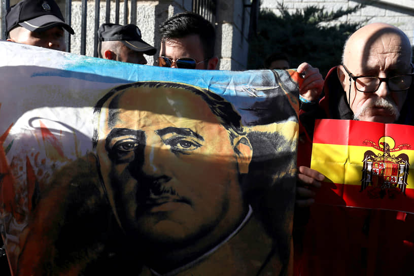 Сторонники покойного испанского диктатора Франсиско Франко держат флаг с его изображением