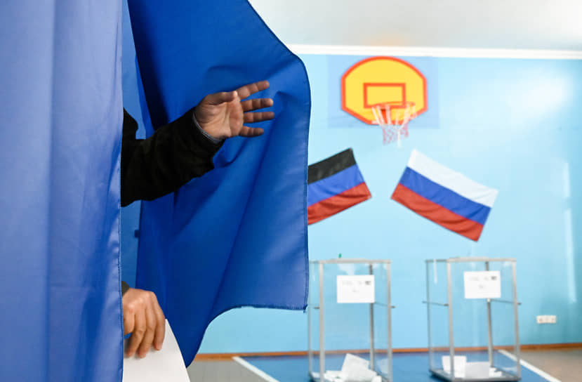 Донецк, ДНР. Местный житель с бюллетенем выходит из кабинки для голосования на референдуме о присоединении к России