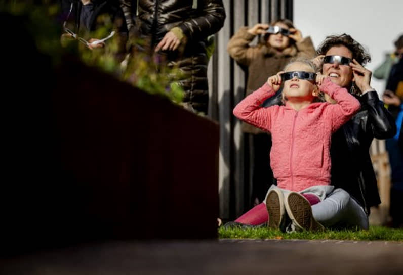 Житель города Утрехт (Нидерланды) наблюдают за затмением
