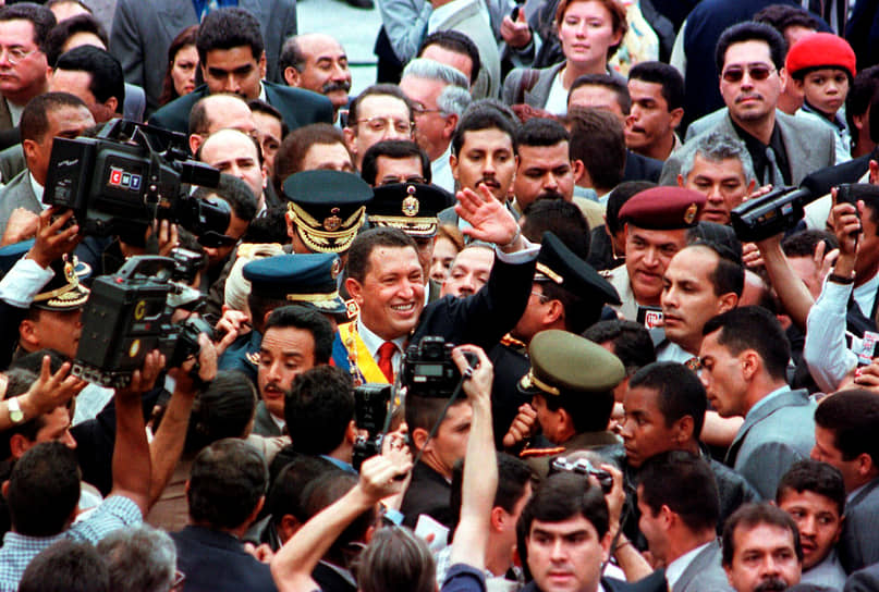 Приведенный к присяге президент Уго Чавес приветствует сторонников во время парада в Каракасе. 1999 год 