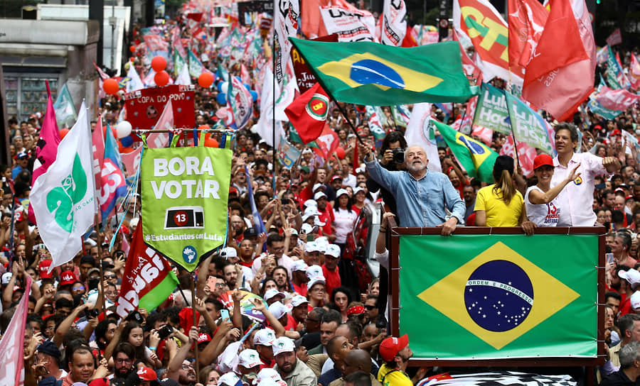 Избранный президент Лула да Силва машет бразильским флагом, возглавляя «марш победы» в Сан-Паулу