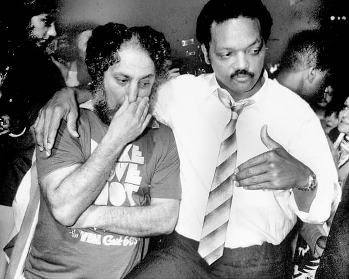 Эбби Хоффман с правозащитником и религиозным деятелем Джесси Джексоном-старшим. 1986 год. На Хоффмане футболка с легендарным лозунгом 1960-ых «Занимайся любовью, а не войной»