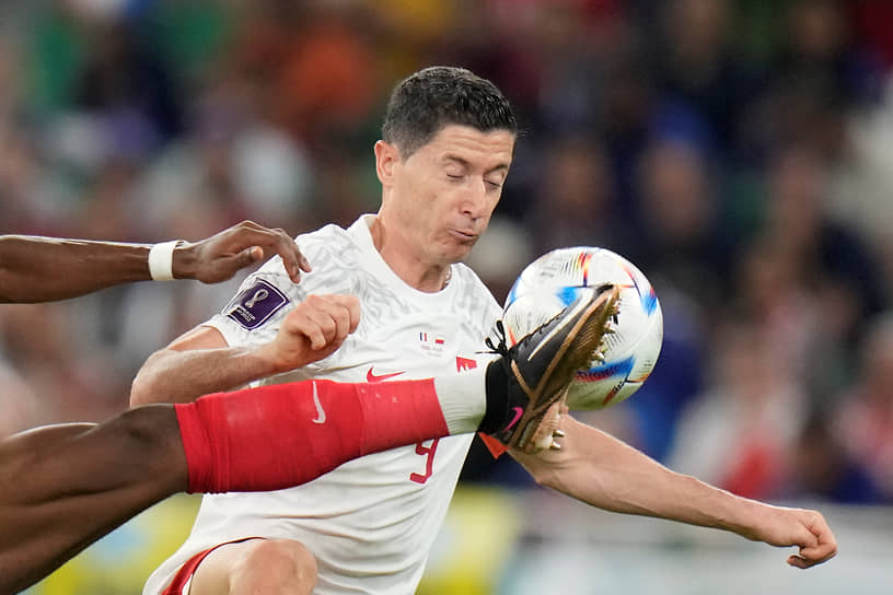 Французский футболист Орельен Чуамени выбивает мяч перед польским игроком Робертом Левандовски 