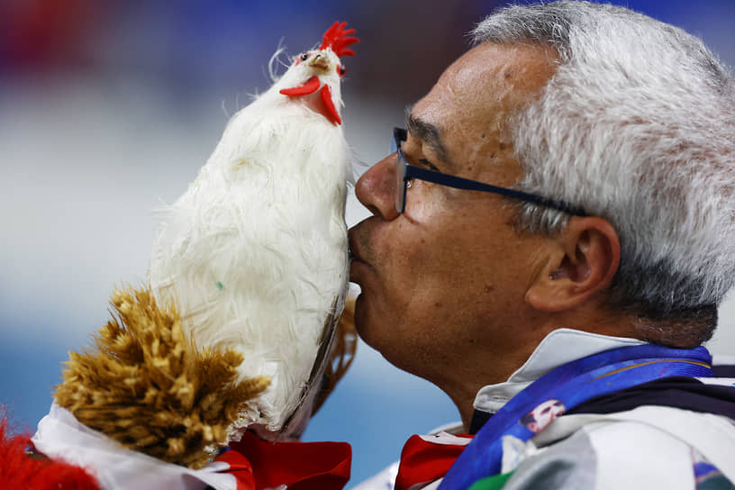 Французский болельщик целует галльского петуха — символ национальной сборной — перед началом матча с командой Австралии