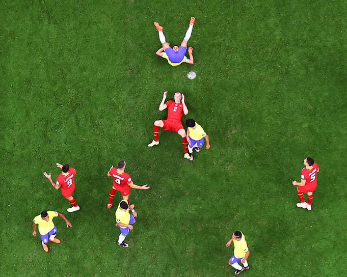 Защитник сборной Сербии Страхиня Павлович (в центре) лежит на поле во время матча с Бразилией