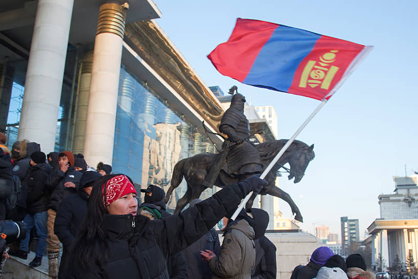 Протестующий размахивает национальным флагом Монголии