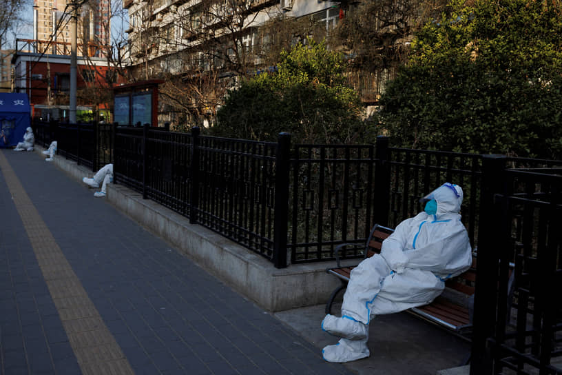 Пекин, Китай. Медработники в защитных костюмах следят за домом, жители которого находятся на карантине из-за коронавируса