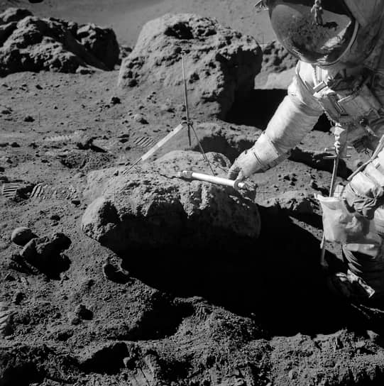Астронавт Дэвид Скотт берет пробу лунного грунта