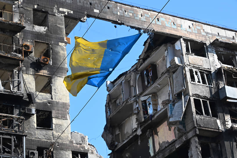 Флаг Украины на фоне разрушенного дома в Мариуполе