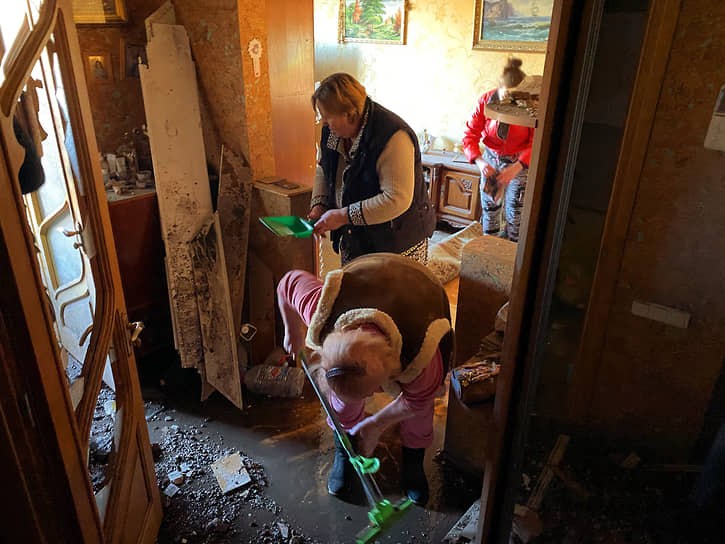 Женщины убираются в квартире, поврежденной в результате обстрела Петровского района Донецка