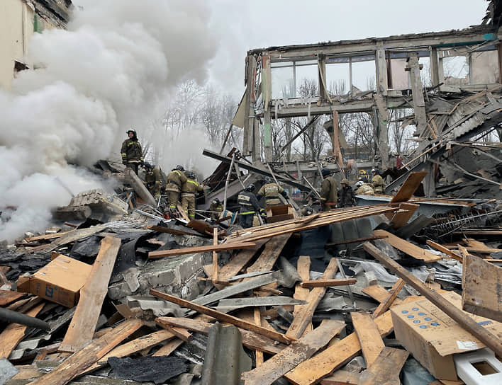 Сотрудники пожарной службы на месте разрушенного торгового центра в Донецке