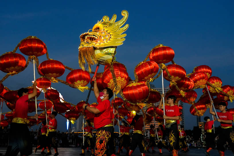 Бангкок, Таиланд.  Местные жители исполняют танец дракона в преддверии китайского Нового года