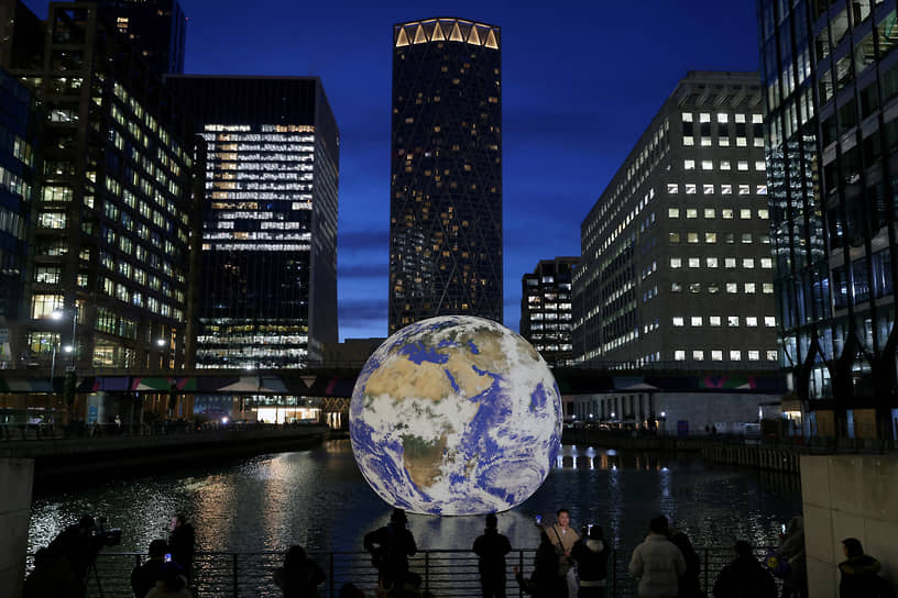 Лондон, Великобритания. Люди смотрят на инсталляцию «Земля» Люка Джеррама, установленную в рамках фестиваля Canary Wharf Winter Lights 