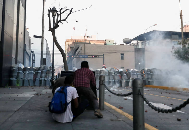 Лима, Перу. Демонстранты в укрытии на антиправительственной демонстрации после свержения бывшего президента Перу Педро Кастильо